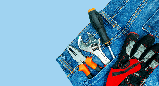Tools in jeans pocket on a blue background