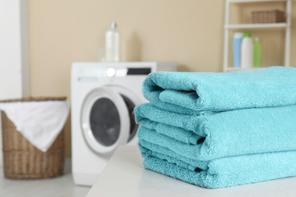 Towels folded in front of a tumble dryer