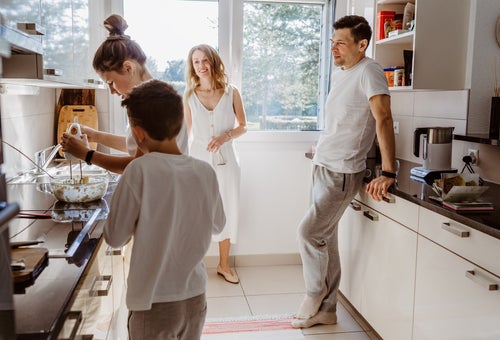 Caucasian mother, father, daughter and son cooking in the kitchen