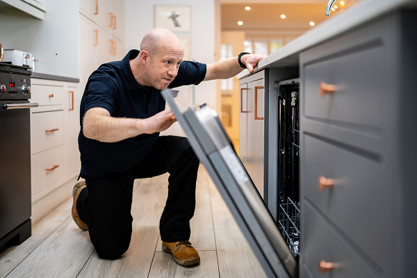Male engineer fixing a dishwasher